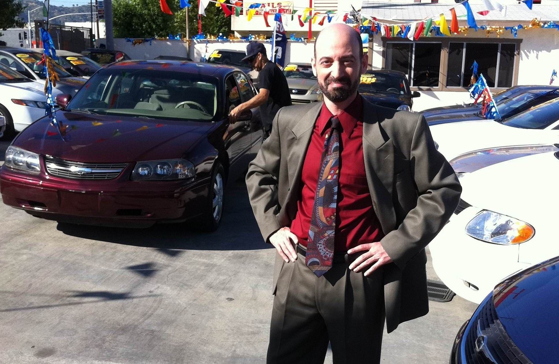 Actor Jeff Blumberg on set shooting a TV commercial, playing the role of a used car salesman